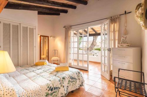 a bedroom with a bed and a large window at Duna in Playa de Muro