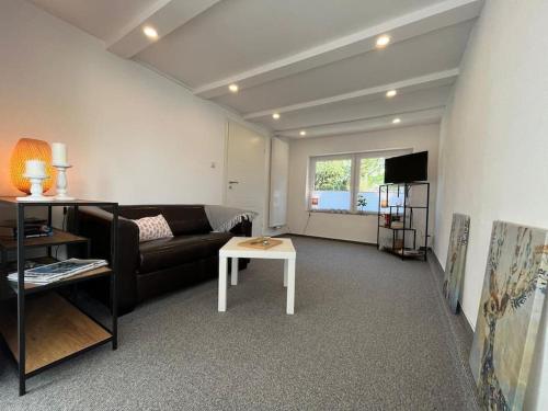 a living room with a couch and a table at Idyllisches Ferienhäuschen Rendsburg in Rendsburg