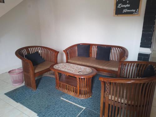 - un salon avec deux chaises et un canapé dans l'établissement Homestay wahyu abadi 2 syariah, à Diyeng