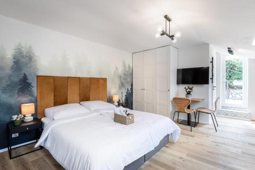 a bedroom with a large white bed and a desk at Penzion Mácha in Litoměřice