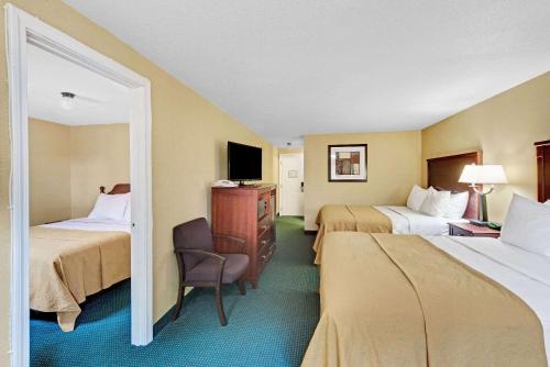 um quarto de hotel com duas camas e uma cadeira em Ramada by Wyndham Kittery em Kittery