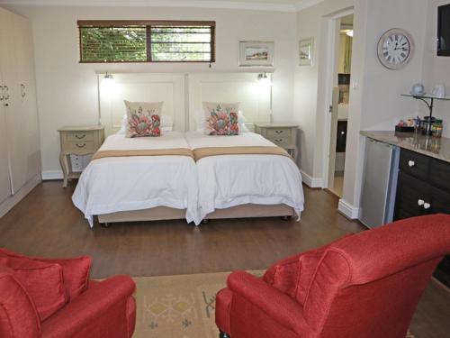 a bedroom with a large bed and two chairs at Caledon 23 Country House in George