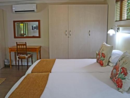 a bedroom with a bed with a desk and a chair at Caledon 23 Country House in George