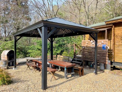 a picnic shelter with a picnic table and a grill at るり渓 フレアキャビン in Nantan city