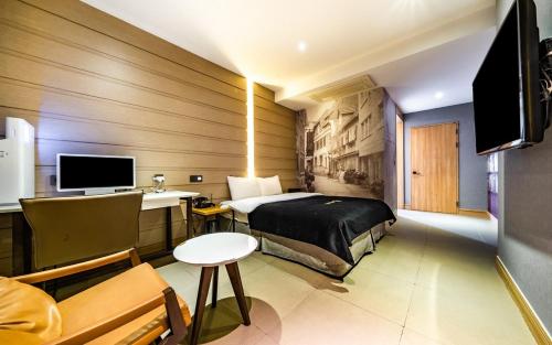 - une chambre avec un lit et un bureau avec un ordinateur dans l'établissement Cherbourg Hotel, à Gwangmyeong