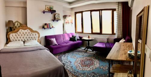 uma sala de estar com uma cama e um sofá roxo em Pera Suites I- Taksim merkez -Klimalı em Istambul