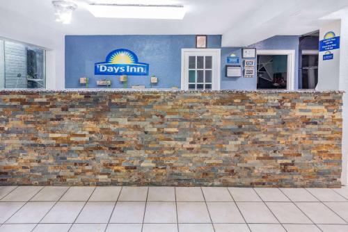 a brick wall with a days inn sign on it at Days Inn by Wyndham Raleigh Glenwood-Crabtree in Raleigh