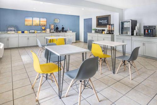 a restaurant with tables and chairs and a counter at Days Inn by Wyndham Raleigh Glenwood-Crabtree in Raleigh