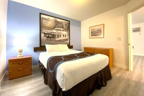 a bedroom with a large bed and a painting on the wall at Super 8 by Wyndham Sicamous in Sicamous