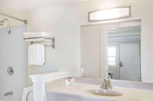 a bathroom with a sink and a large mirror at Travelodge by Wyndham Fairfield/Napa Valley in Fairfield