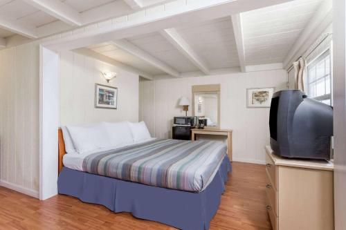 a bedroom with a bed and a flat screen tv at Travelodge by Wyndham Fairfield/Napa Valley in Fairfield