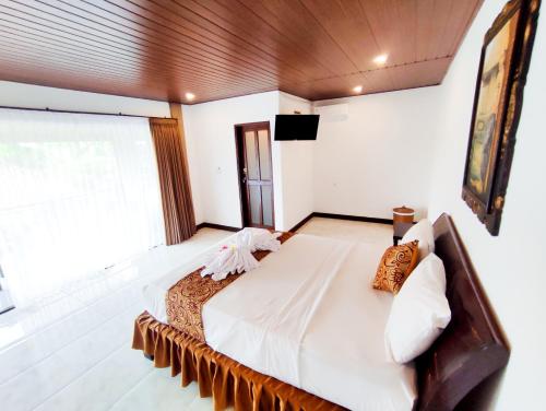 a bedroom with a large bed and a large window at The Bali Menjangan Boutique Villas & Dive Center in Pemuteran