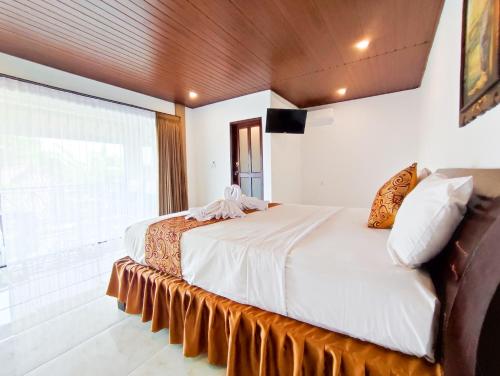 a bedroom with a bed and a large window at The Bali Menjangan Boutique Villas & Dive Center in Pemuteran