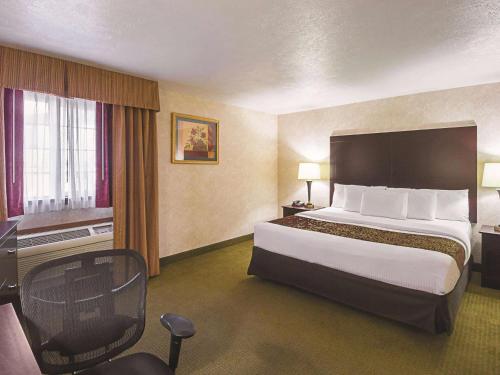 a hotel room with a large bed and a desk at La Quinta by Wyndham Woodburn in Woodburn