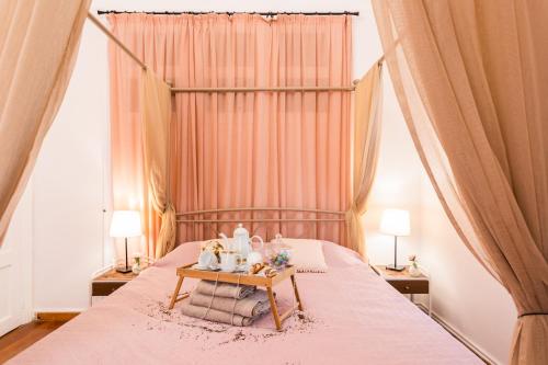 a bedroom with a pink bed with a table with towels at Alegria rooms in Athens