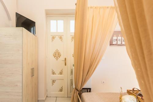 a bedroom with a door and a window with curtains at Alegria rooms in Athens