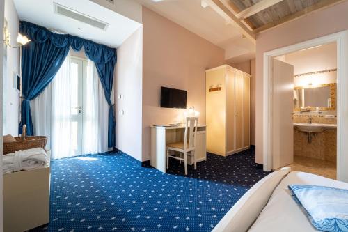 a hotel room with a bed and a desk at Hotel Borgo dei Poeti Romantik Wellness & SPA in Manerba del Garda