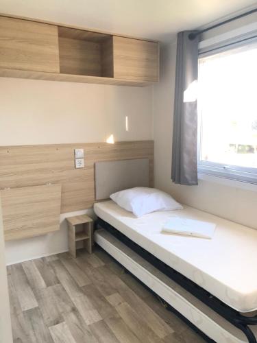 a small bedroom with a bed and a window at Azur in Fréjus