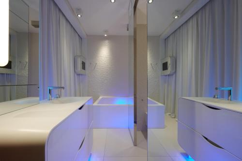 La salle de bains est pourvue de 2 lavabos et de 2 miroirs. dans l'établissement i-Suite Hotel, à Rimini