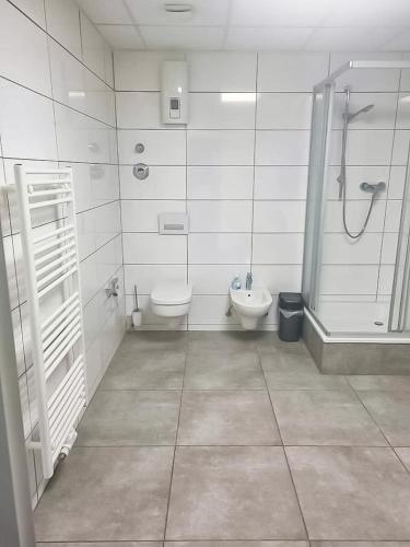 La salle de bains est pourvue de toilettes, d'une douche et d'un lavabo. dans l'établissement PREMIUM - 24 Betten - 9 Appartements zentral in Oer-Erkenschwick - homes of ruhr, à Oer-Erkenschwick