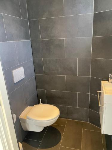 La salle de bains est pourvue de toilettes et d'un mur carrelé. dans l'établissement Hotel Doppenberg, à Zandvoort