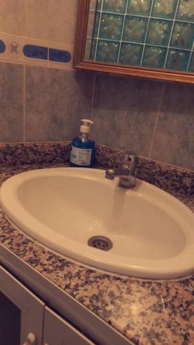 a bathroom sink with a bottle of soap on it at Bel appartement ,uniquement pour les familles in Meknès