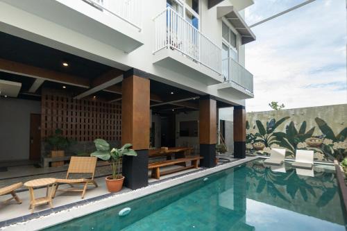 eine Villa mit einem Pool und einem Haus in der Unterkunft Sarang Comfort in Canggu