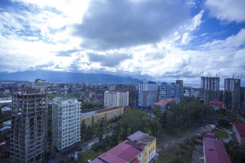 a city with tall buildings and a cloudy sky at Aparthotel Tangerine in Batumi