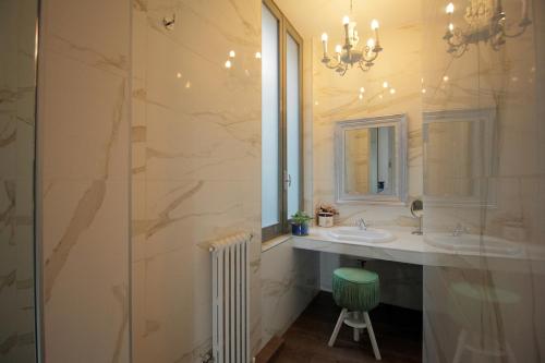 un bagno con due lavandini e una doccia in vetro di Antica Locanda Dei Mercanti a Milano