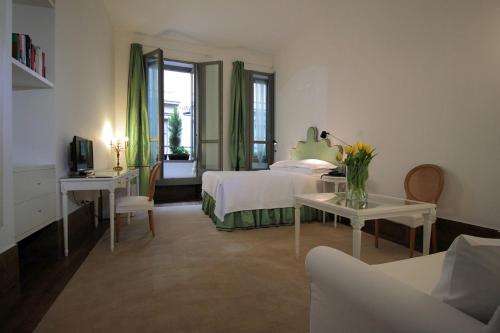 a bedroom with a bed and a table and a couch at Antica Locanda Dei Mercanti in Milan