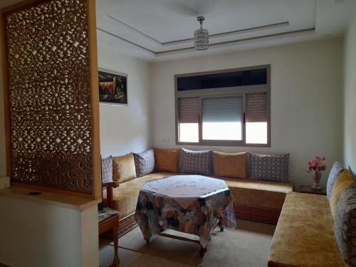 a living room with a couch and a table at Appartement meublé ennasr49 in Khenifra