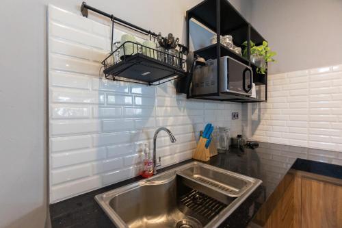 eine Küche mit einer Edelstahlspüle in der Küche in der Unterkunft Sarang Comfort in Canggu