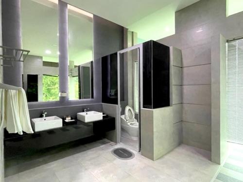 a large bathroom with two sinks and a toilet at Teluk Cempedak Seventh Haven in Kuantan