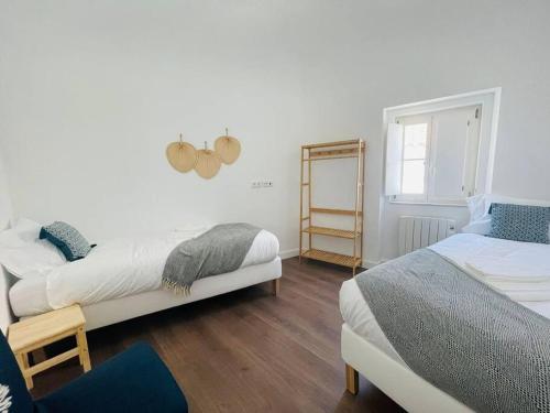 a bedroom with two beds and a mirror on the wall at Casa da Oliveira in Évora