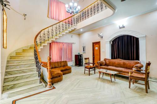 a living room with a staircase and a couch at FabHotel Raka Inn in Allahābād