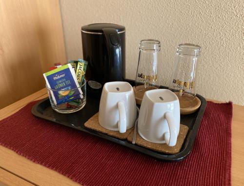 a tray with two mugs and glasses on a table at MOSELTEL Ernst,Cochem in Ernst