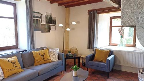salon z kanapą i 2 krzesłami w obiekcie Gite : Le vi colombage de Petites-Tailles w mieście Vielsalm