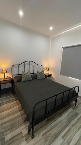 1 dormitorio con cama y pantalla de proyección en LAS MESAS HOUSE Ocean Escape, en San Miguel de Abona