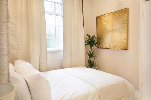 a bedroom with a white bed and a window at Beautifully Decorated & Central 2bed Apartment (C) in Brighton & Hove