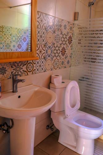a bathroom with a white toilet and a sink at Graneroverde Resort in Al Qbayyāt