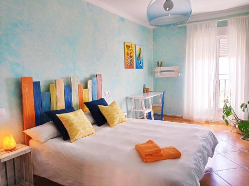 Un dormitorio con una gran cama blanca con almohadas. en La Casa Viva. Alojamiento responsable y sostenible., en Vélez Blanco