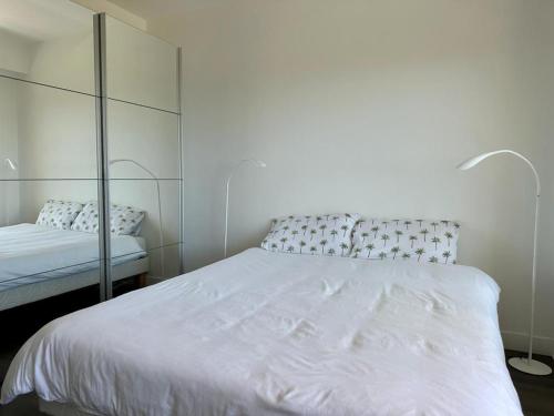 ヴィルヌーヴ・ルベにあるBel appartement avec vue merのベッドルーム(白いベッド1台、鏡付)