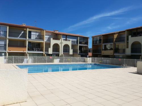 - une piscine en face de deux immeubles d'appartements dans l'établissement 100m de la plage richelieu + piscine, au Cap d'Agde