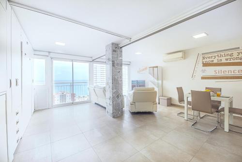 Myflats Premium Costa Blanca في أليكانتي: غرفة فارغة مع طاولة وكراسي في مبنى