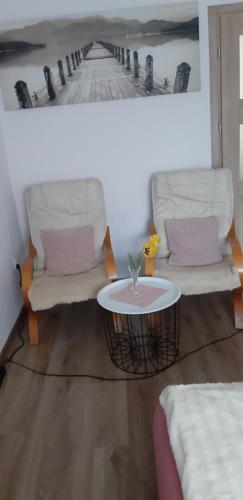a living room with two chairs and a table at Apartament u Janiny in Jeżów Sudecki