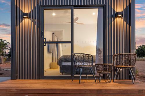 two chairs and a table in front of a house at Three Ponds Estate in Temora