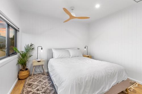 a white bedroom with a bed and a window at Three Ponds Estate in Temora
