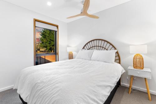 a white bedroom with a bed and a window at Three Ponds Estate in Temora