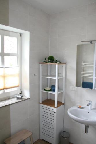 a bathroom with a sink and a white shelf at Haus Brunnenkunst in Arnstadt