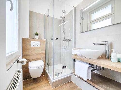 ein Bad mit einer Dusche, einem WC und einem Waschbecken in der Unterkunft Haus Menno Janssen - Ferienwohnung Bella in Norderney